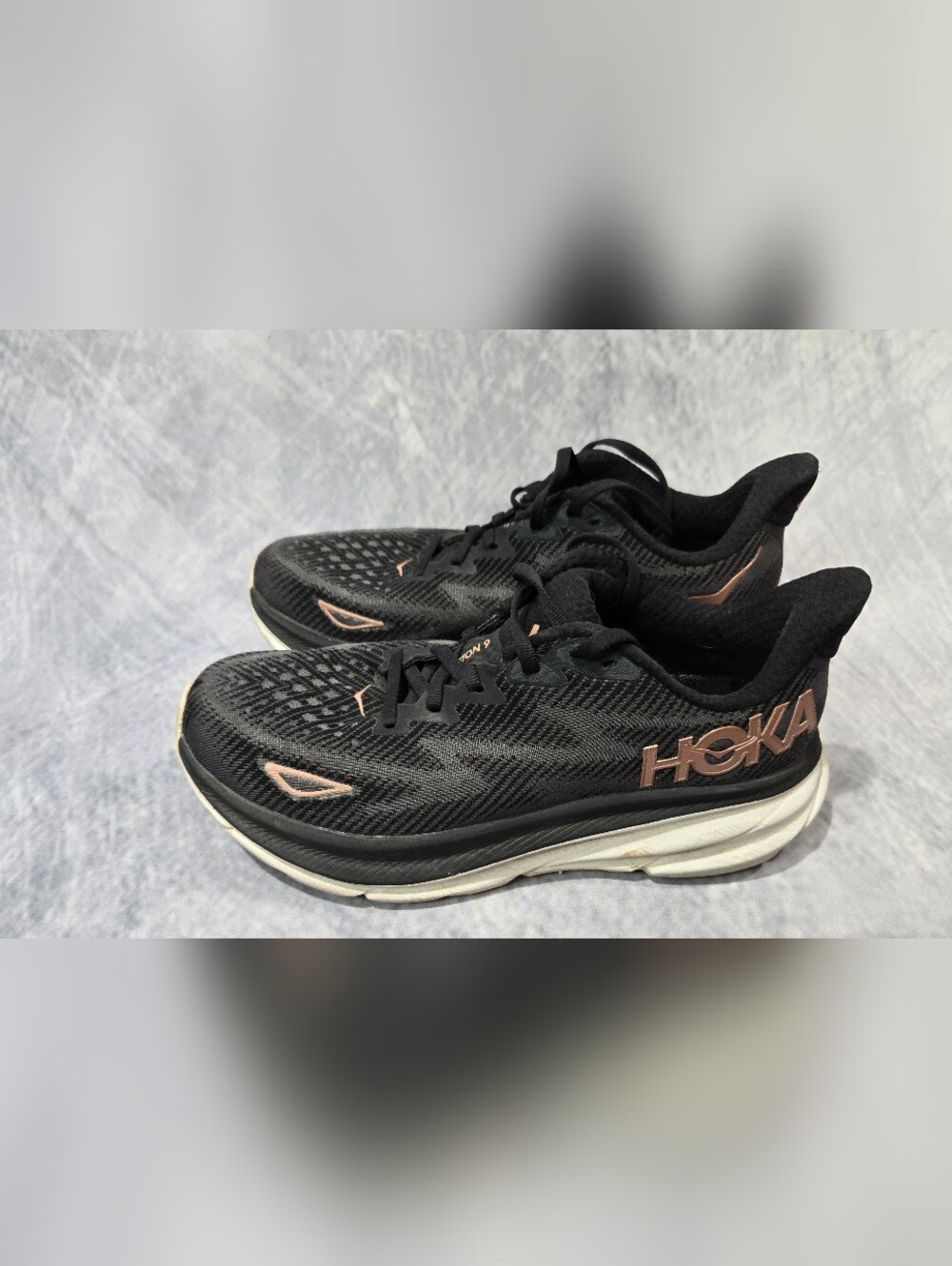 HOKA W Clifton 9 sneakers in a black and rose gold colorway